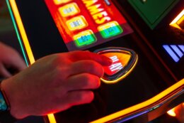 A,Man,Presses,The,Button,To,Play,The,Slot,Machine.